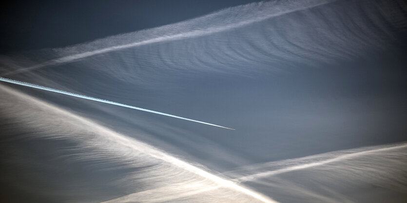 Ein Flugzeug zieht Kondesstreifen am Himmel