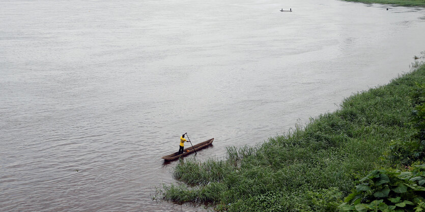 Blick auf den Kongo-Fluss. Ein Mann rudert sein Boot darüber