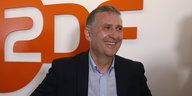 ZDF-Korrespondent Jörg Brase vor dem ZDF-Logo