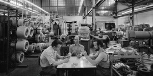 Eine Gruppe von drei Männern spielt Karten in einem DDR-Betrieb