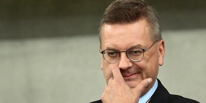 Reinhard Grindel fasst sich ins Gesicht