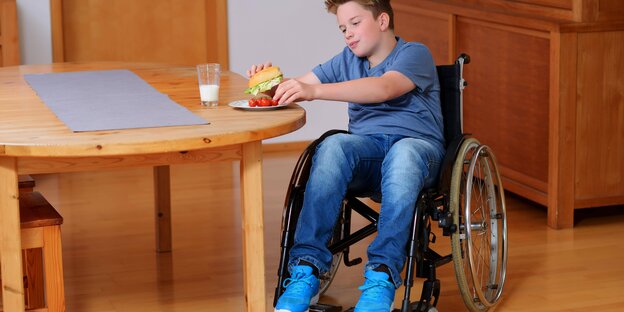 Ein Junge im Rollstuhl an einem Tisch