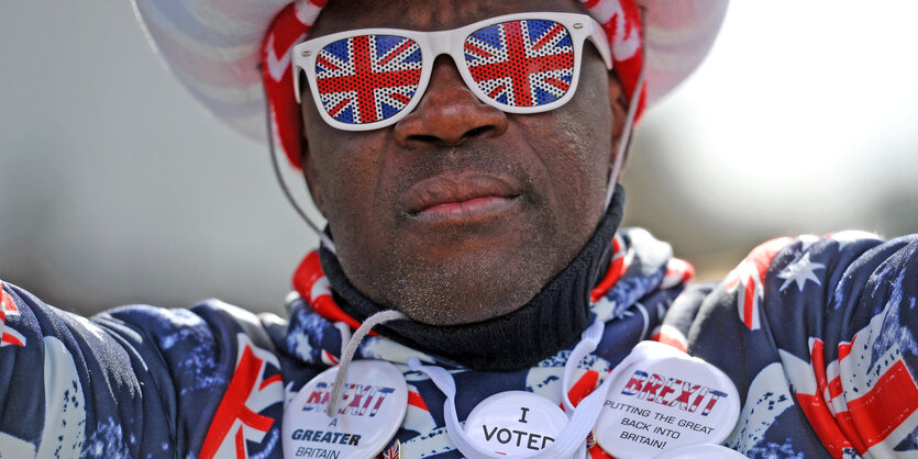 Ein Brexit-Anhänger mit einem Pullover und Buttons in britischem Flaggenmuster nimmt an einem Protest vor dem Parlament in Westminster teil