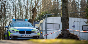 Ein Polizeiwagen parkt neben einem Campingtrailer, der als mutmaßlicher Tatort abgesperrt ist