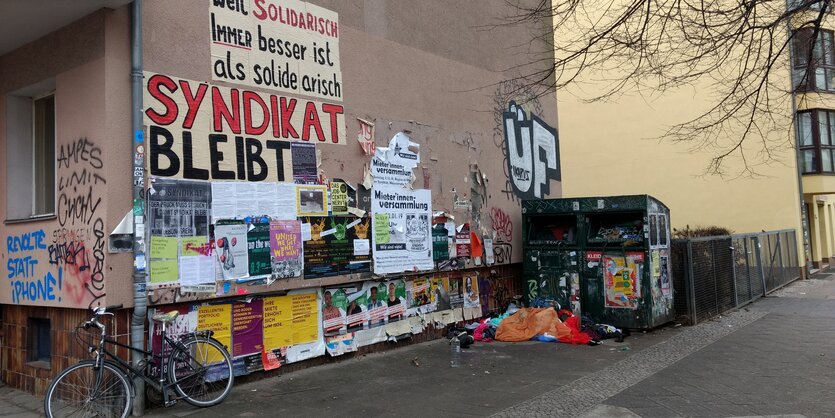 Eine Hauswand im Schillerkiez, die mittels Plakatierung das Bleiben des Syndikats fordert