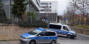 Polizeiautos vor einem Gerichtsgebäude