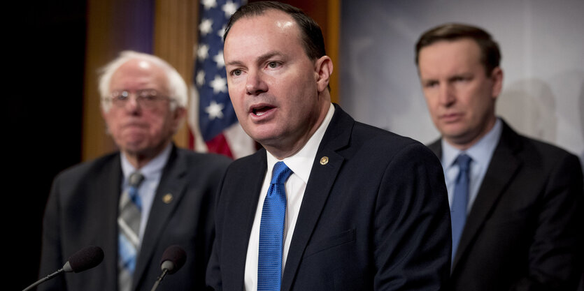 Senator Mike Lee spricht, hinter ihm stehen die US-Senatoren Bernie Sanders und Chris Murphy