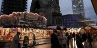 Besucher gehen über den Weihnachtsmarkt am Breitscheidplatz