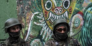 Zwei Soldaten stehen vor einem Wandbild in Rio de Janeiro