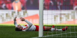 Fußballspieler Timo Werner liegt nach einem Fehlschuss auf dem Rasen vor dem Tor und hebt die Arme in die Luft