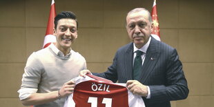 zwei Männer halten ein Özil-Trikot zwischen sich