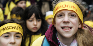 Schüler beteiligen sich an der "Fridays for Future" - Klimademonstration. Zwei Kinder mit Kopfbinden gucken in die Kamera