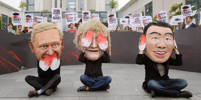 Aktivisten der Organisation Campact demonstrieren 2011 verkleidet als Westerwelle, Merkel und Roesler vor dem Bundeskanzleramt in Berlin.