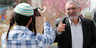 Michael Ben-Ari zeigt mit dem Finger auf einen Mann, der ihn fotografiert.