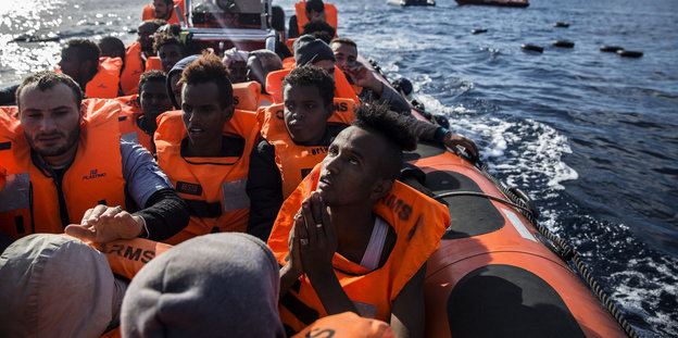 Menschen sitzen in einem Schlauchboot auf dem Mittelmeer