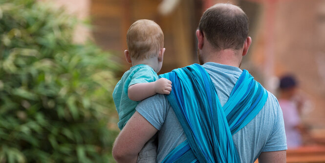 Mann mit Baby und Wickeltuch