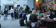 Menschen sitzen an Tischen vor dem Sonntagsclub im Prenzlauer Berg