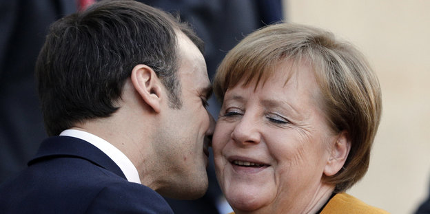 Emmanuel Macron küsst Angela Merkel auf die Wange.