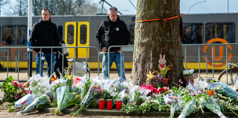 Zwei Männer vor Blumen an einer Straßenbahn