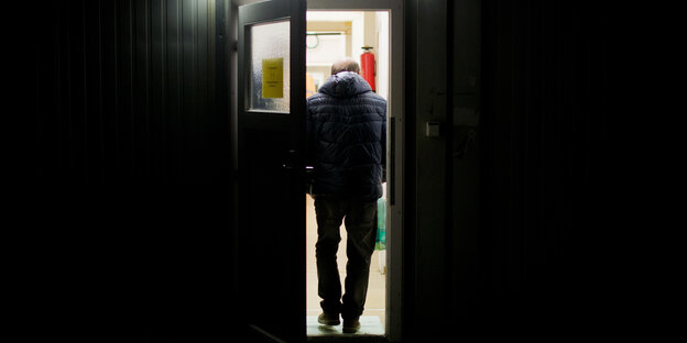 Ein Mann betritt eine Obdachlosenunterkunft.