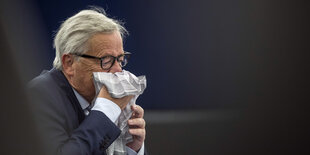 Jean-Claude Juncker schnäuzt in ein Stofftaschentuch.