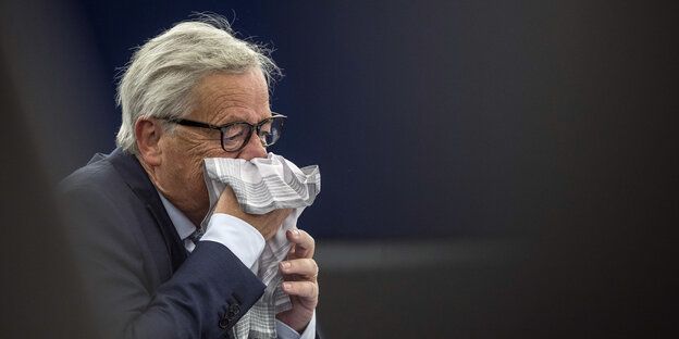 Jean-Claude Juncker schnäuzt in ein Stofftaschentuch.