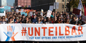 Menschen hinter einem #unteilbar-Transparent auf einer Demo in Berlin