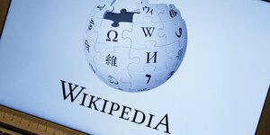 Der Schriftzug und das Zeichen von Wikipedia, ein Erdball aus Puzzleteilen, auf einem Laptop-Bildschirm