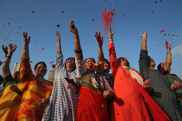 Frauen in roten Kleidern werfen Rosenblüten in den Himmel