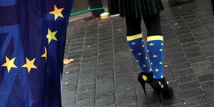 Eine Frau trägt blaua Socken mit gelben Sternen, der EU-Flagge ähnlich