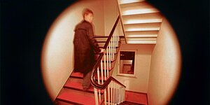 Eine Person geht durch ein Treppenhaus.