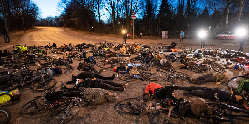 Radfahrer*innen und Fahrräder liegen auf einer Kreuzung in Hamburg