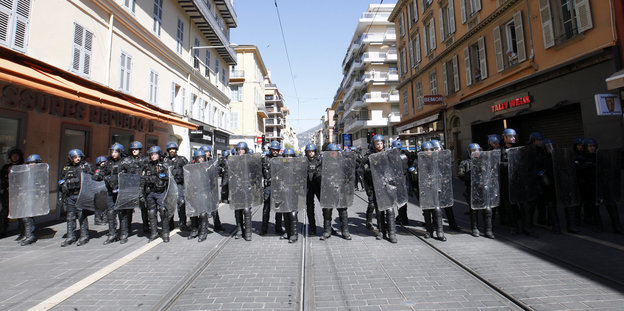 Eine Reihe Polizisten in Riotgear auf der kompletten Breite einer Straße