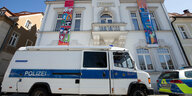 Das Rathaus der Stadt Ostritz mit herunterhängenden Bannern und davor zwei Polizeiwagen