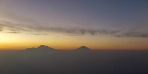 Dämmerung, Himmel und zwei Vulkane am Horizont
