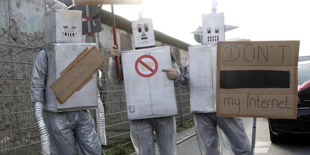 Drei als Bots verkleidete DemonstrantInnen