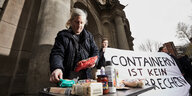 Tobias K. legt Lebensmittel auf einen Klapptisch, der vor dem Amtsgericht in Hannover aufgebaut ist.