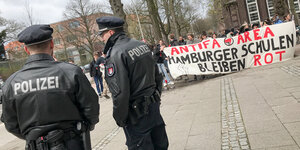 Demo von Hamburger Schülerinnen. Im Vordergrund: zwei Polizisten