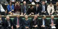 Abgeordnete sitzen im britischen Parlament auf den Bänken. Viele lachen.