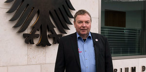 Claus-Peter Reisch in Hemd und Sakko an der Pforte des Innenministeriums