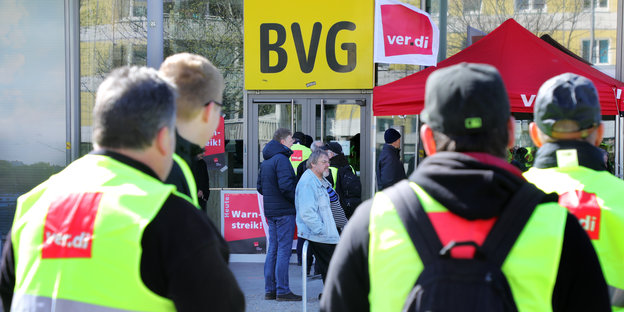 Mitarbeiter der Berliner Verkehrsbetriebe (BVG) stehen vor einer Geschäftstelle des Unternehmens im Bezirk Mitte und nehmen an einem ganztägiger Warnstreik teil