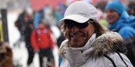 Profil Hansi Hinterseer mit weißer Jacke und weißer Cap. Es schneit leicht
