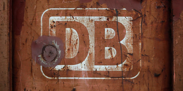 ein DB-Zeichen auf einer rostigen Oberfläche - vermutlich eines Zuges der Deutschen Bahn