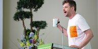 Landesvorsitzender Werner Graf steht an einem Plut und hält eine Rede bei einem Parteitag der Berliner Grünen