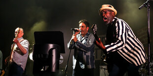 Bassist Horace Panter, Sänger Terry Hall und Gitarrist Lynval Golding von den Specials auf der Bühne in Berlin.