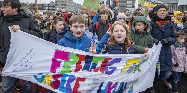 Kinder und Erwachsene demonstrieren, sie halten ein Banner, auf dem steht: Freitag für unsere Zukunft