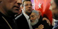 Imamoglu nimmt einen älteren Herrn in den Arm. Im Hintergrund eine türkische Flagge.