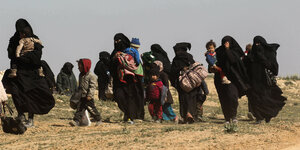 Frauen fliehen mit ihren Kindern aus dem IS-Dorf im Osten des Landes.