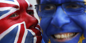 Ein mit UK-Flagge bemaltes Gedicht küsst ein mit EU-Flagge bemaltes Gesicht