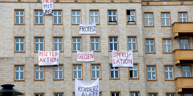 Ein Haus in der Karl-Marx-Allee ist mit Protest-Plakaten behängt